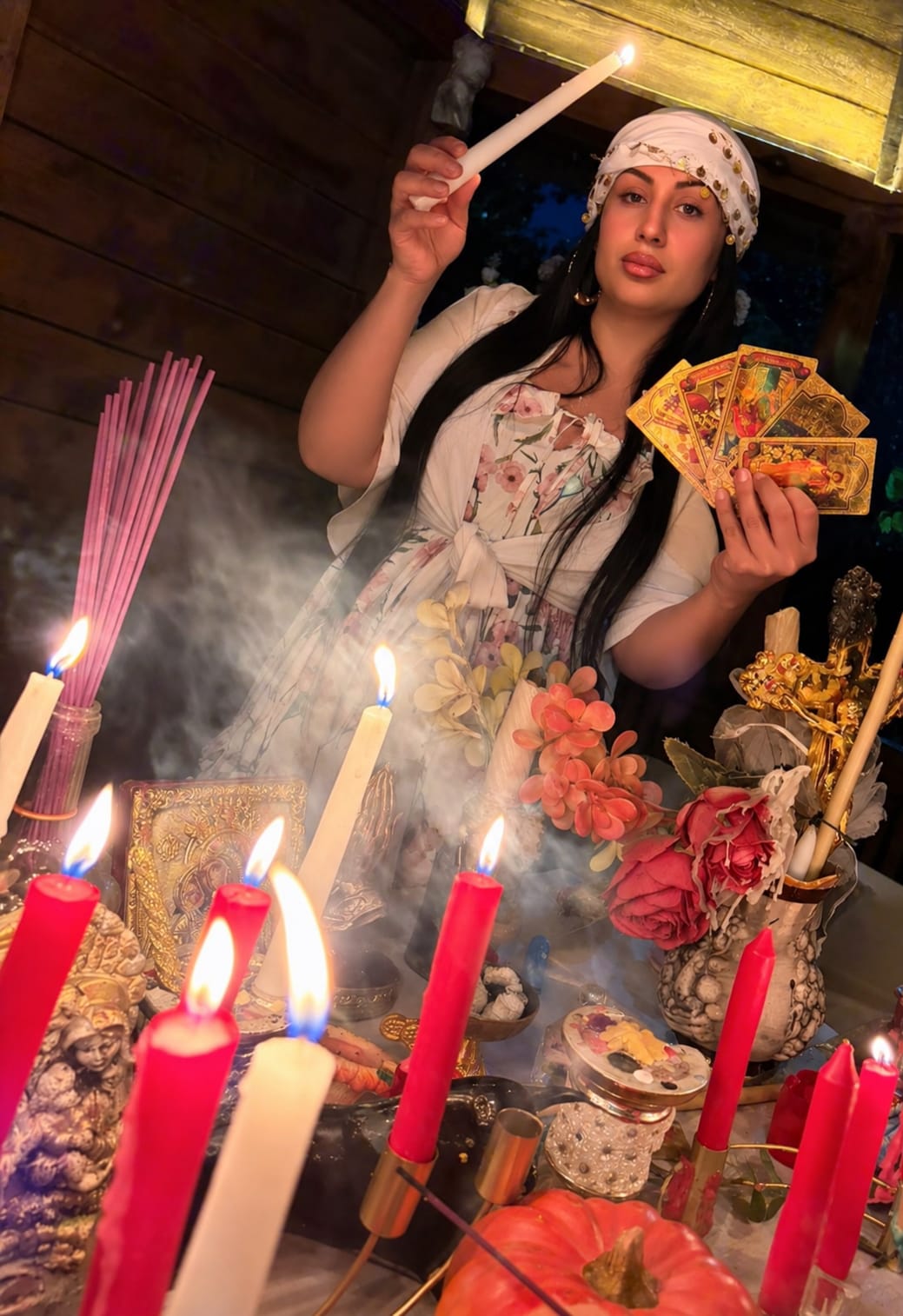 Clarvăzătoarea Flory ținând cărți de tarot, printre lumânări aprinse